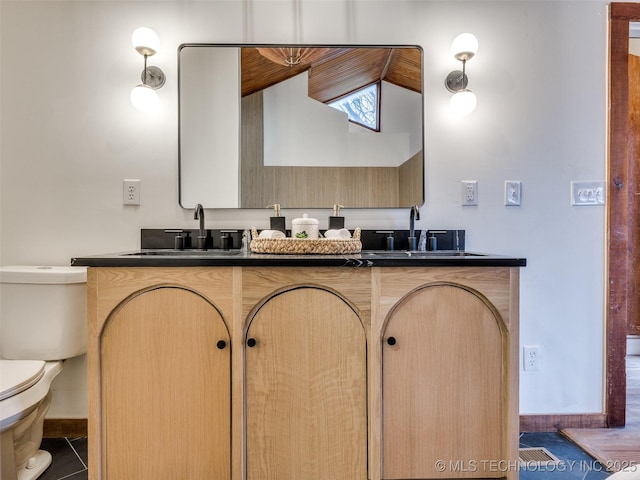 full bath featuring a sink, toilet, and double vanity