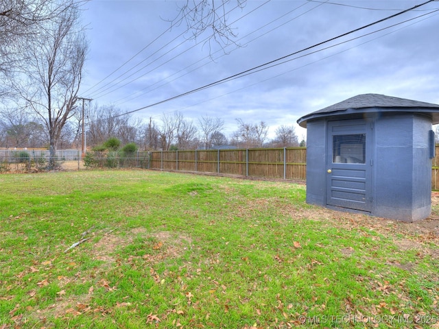 view of yard with an outbuilding, a shed, and a fenced backyard