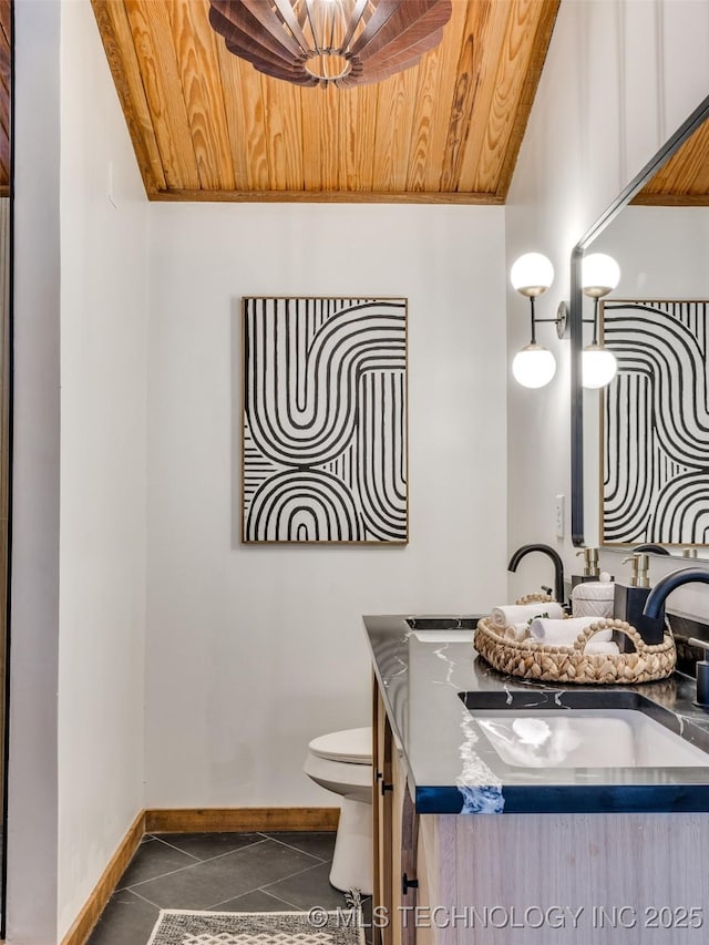 half bath with toilet, vanity, tile patterned flooring, wooden ceiling, and baseboards