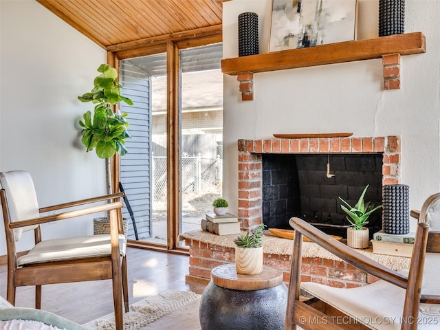 interior space featuring wood ceiling, a fireplace, a wall of windows, and wood finished floors