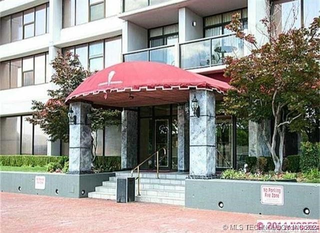 property entrance featuring a balcony and stucco siding