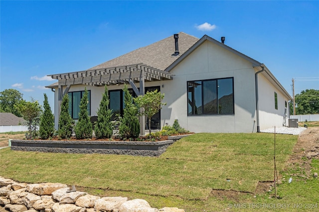 rear view of property with a lawn, central AC unit, and a pergola