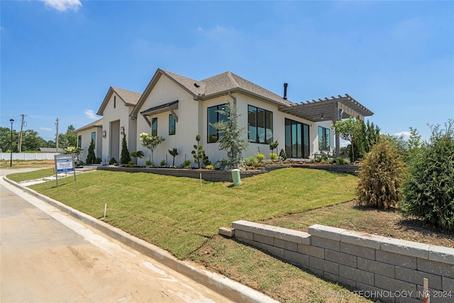 view of front facade with a pergola and a front lawn