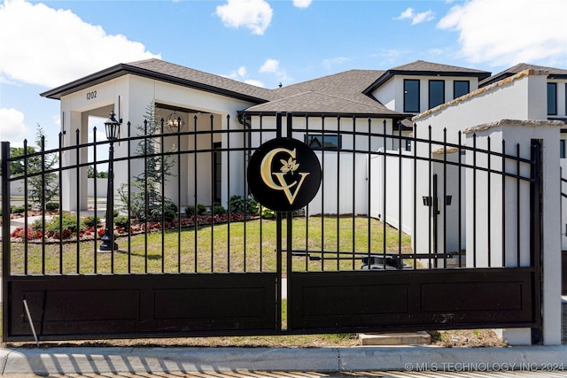 view of gate featuring a lawn and a garage