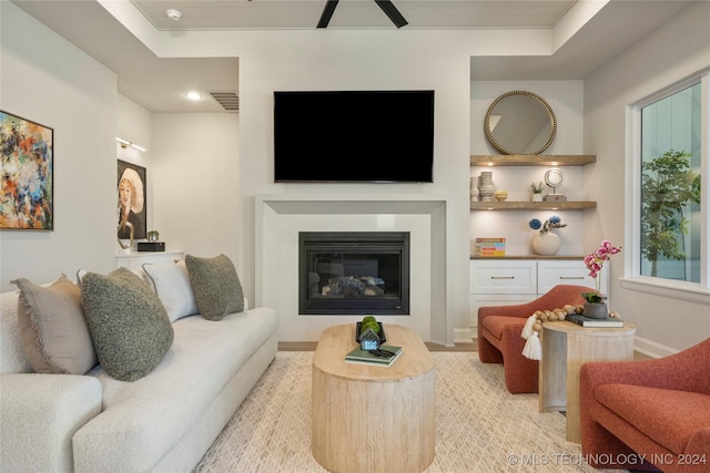 living room featuring a tray ceiling and crown molding