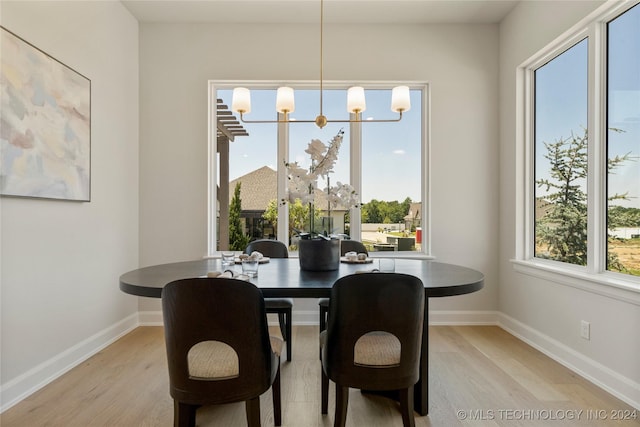 dining room with light hardwood / wood-style floors and an inviting chandelier