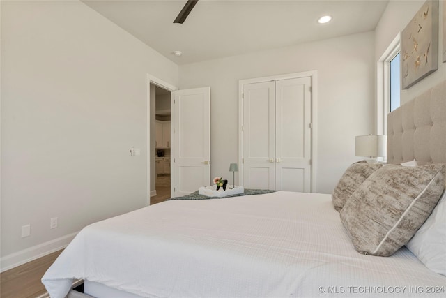 bedroom with ceiling fan, wood-type flooring, and a closet