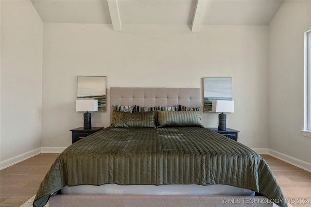 bedroom featuring beam ceiling and hardwood / wood-style floors