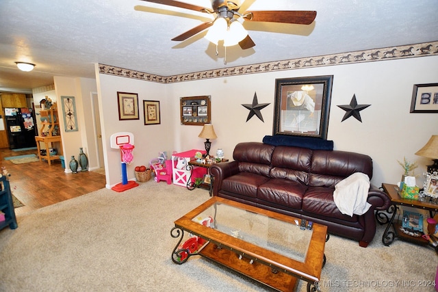 carpeted living room with a textured ceiling and ceiling fan