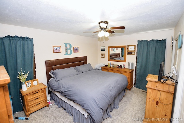 bedroom featuring light carpet, a textured ceiling, and ceiling fan