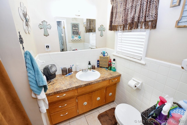 bathroom with tile patterned floors, vanity, tile walls, and toilet