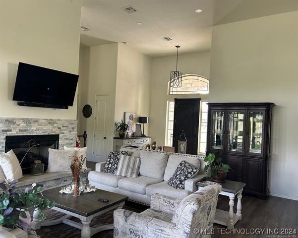 living room featuring a fireplace, a high ceiling, and hardwood / wood-style floors