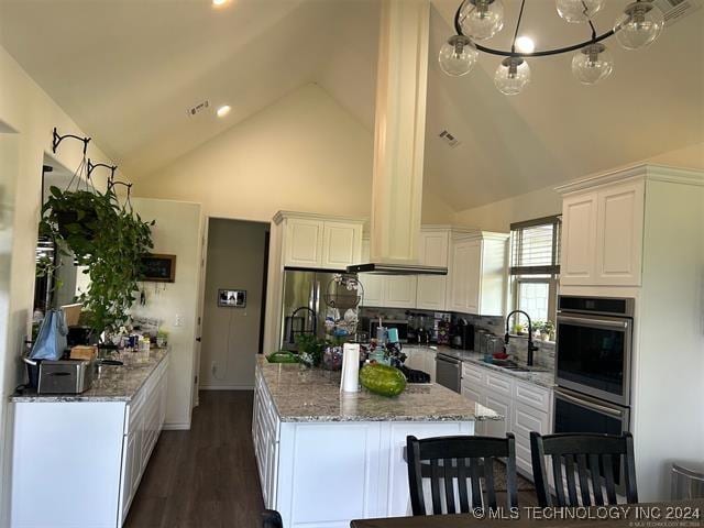 kitchen featuring white cabinets, backsplash, light stone countertops, and sink