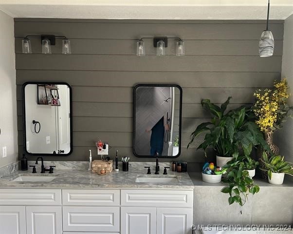 bathroom featuring vanity and wood walls