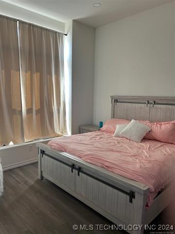 bedroom with dark hardwood / wood-style floors