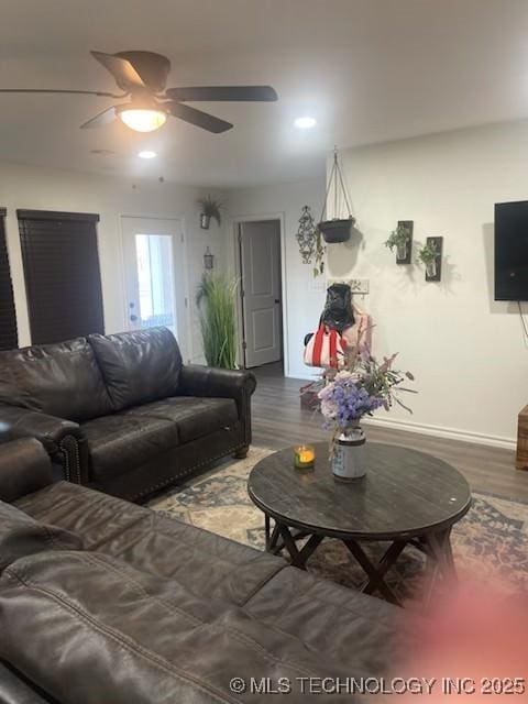 living room featuring ceiling fan and dark hardwood / wood-style flooring