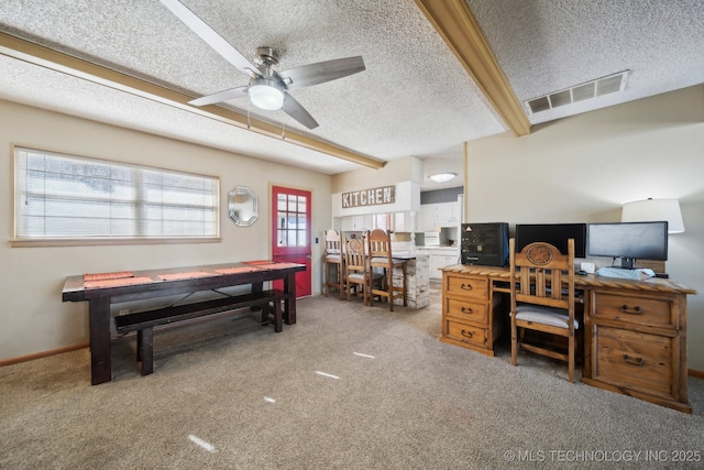 office area featuring ceiling fan, a textured ceiling, beamed ceiling, and carpet flooring