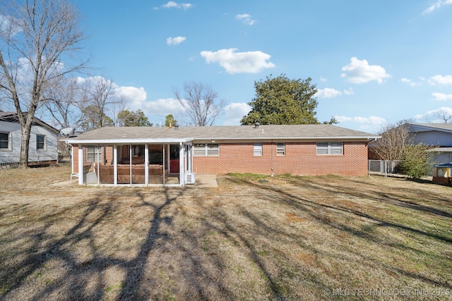 rear view of house with a sunroom and a lawn