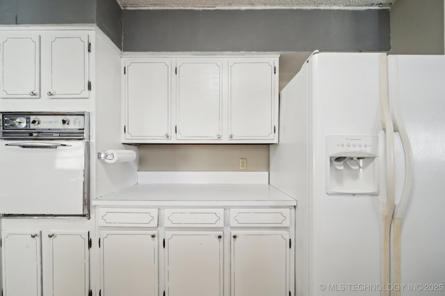 kitchen with white cabinetry and white appliances