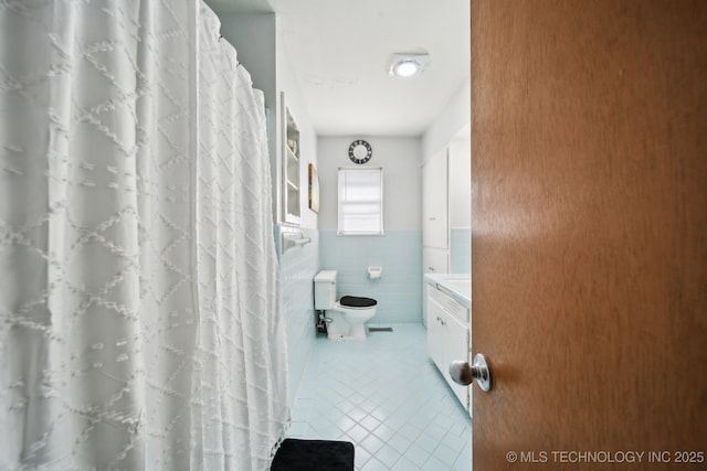 bathroom with tile walls, tile patterned flooring, and toilet