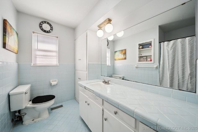 bathroom featuring vanity, tile walls, tile patterned floors, and built in shelves