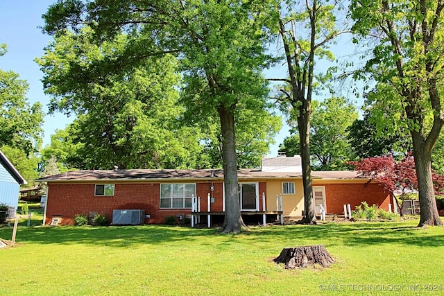 rear view of property with a yard and cooling unit