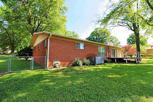 view of side of home featuring a lawn and central AC unit