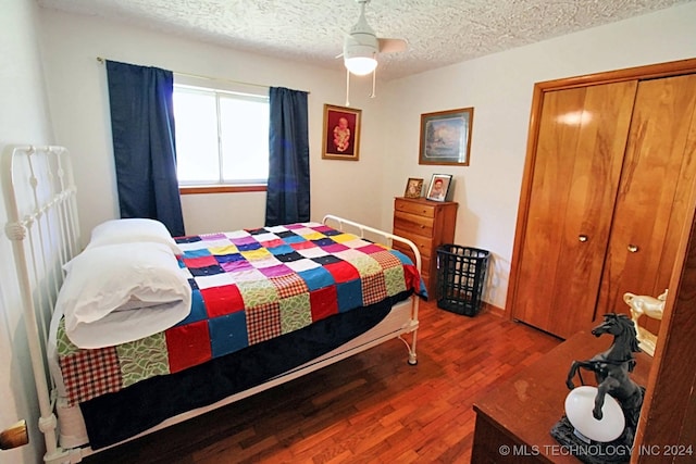 bedroom with hardwood / wood-style floors, ceiling fan, a textured ceiling, and a closet