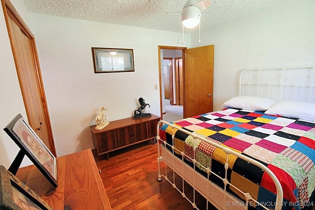 bedroom featuring a textured ceiling, dark hardwood / wood-style flooring, and ceiling fan