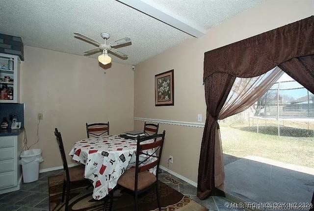 dining area with ceiling fan and a textured ceiling