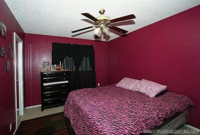 bedroom with ceiling fan and a textured ceiling