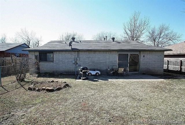 back of property with a patio area and a lawn