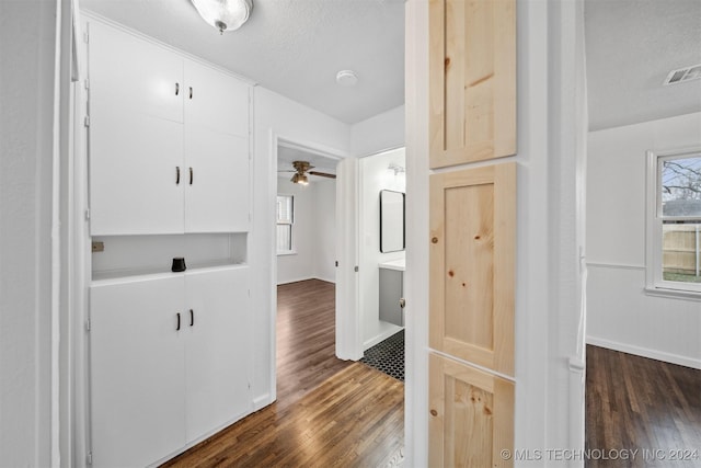 hall featuring dark wood-type flooring and a textured ceiling