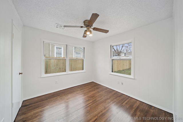 unfurnished room featuring a textured ceiling, dark hardwood / wood-style flooring, and ceiling fan