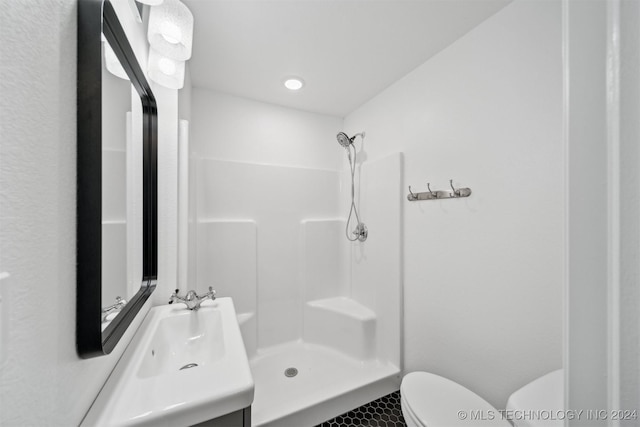 bathroom featuring vanity, toilet, and a shower