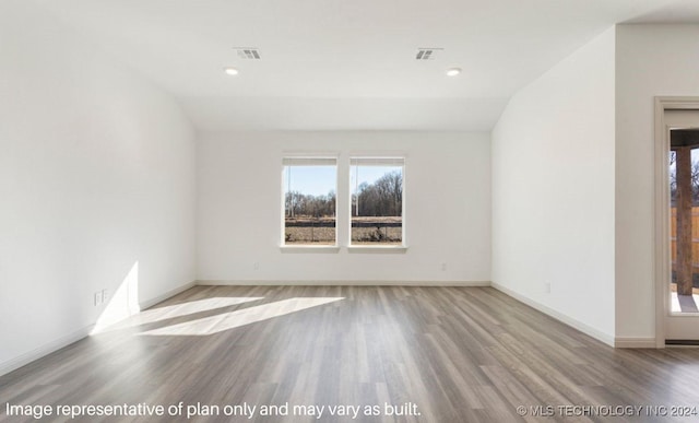 unfurnished room featuring light hardwood / wood-style floors and vaulted ceiling