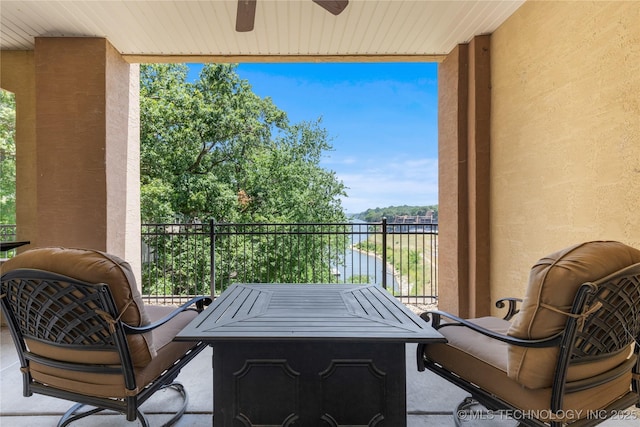 balcony featuring ceiling fan and a water view