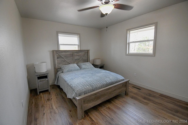 bedroom with hardwood / wood-style flooring, ceiling fan, and multiple windows