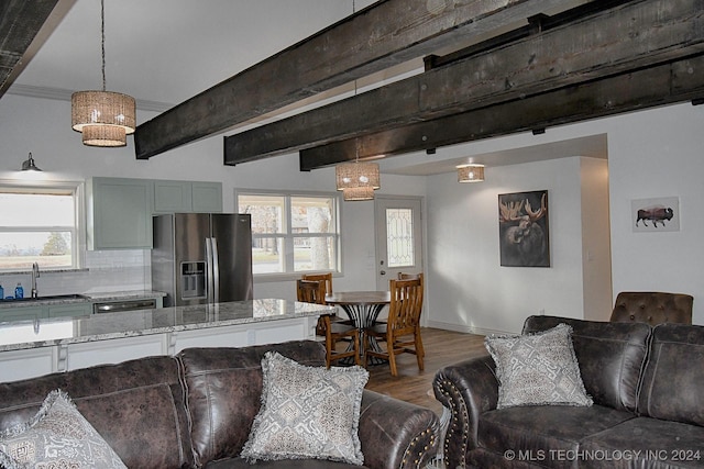 living room with hardwood / wood-style floors, beam ceiling, and sink