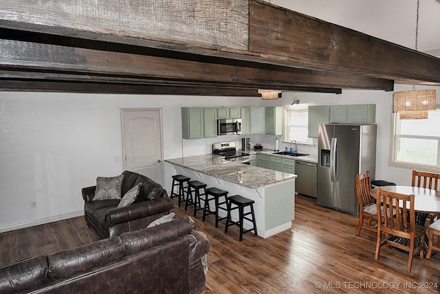 kitchen featuring stone counters, green cabinets, appliances with stainless steel finishes, kitchen peninsula, and a breakfast bar area