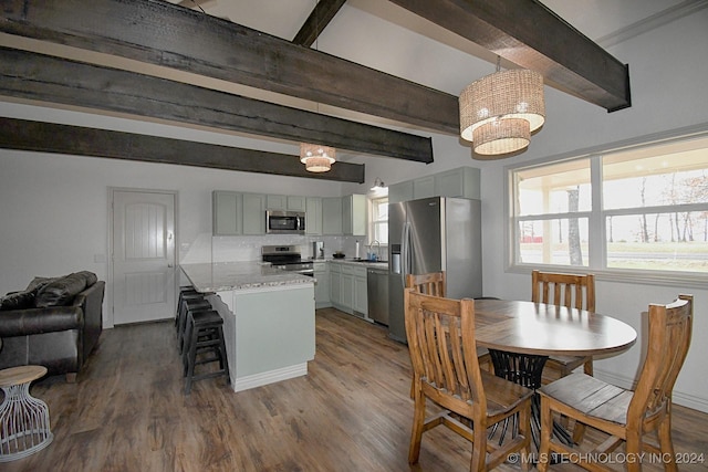 kitchen with beam ceiling, gray cabinetry, a center island, stainless steel appliances, and pendant lighting