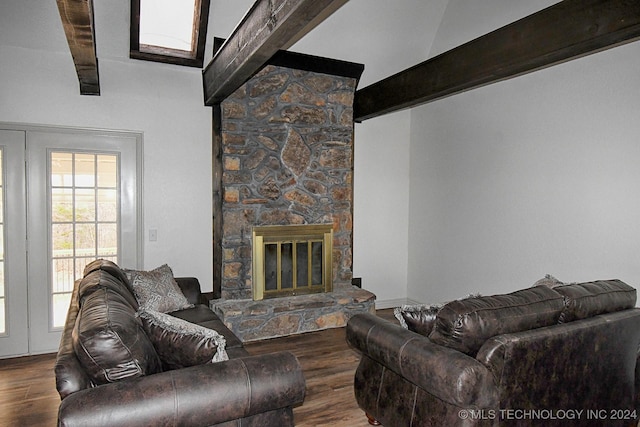 living room featuring dark hardwood / wood-style flooring, beam ceiling, and a stone fireplace