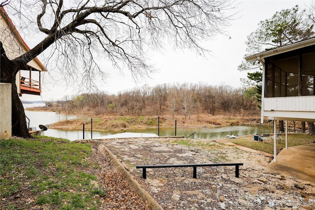 view of yard featuring a sunroom and a water view