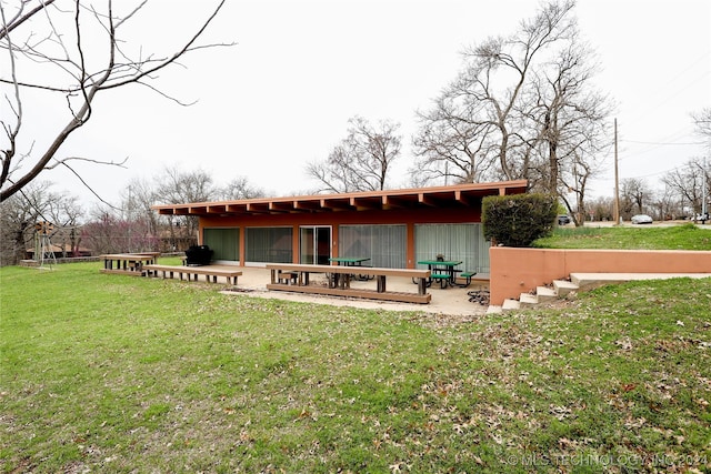 rear view of property featuring a patio area and a yard