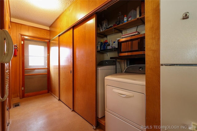 laundry area with a textured ceiling and washing machine and clothes dryer