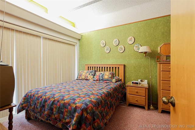 bedroom featuring crown molding, carpet floors, and a textured ceiling