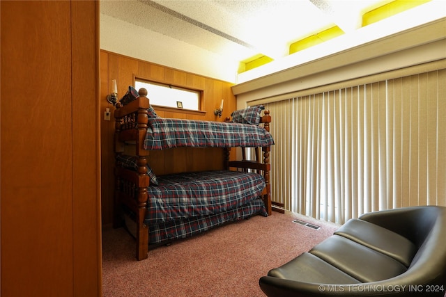 carpeted bedroom with wood walls