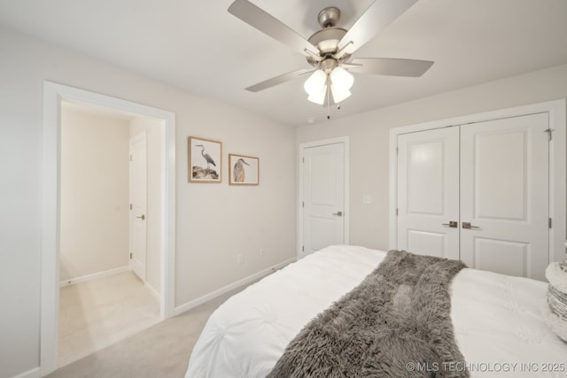 bedroom with light carpet, ceiling fan, baseboards, and a closet