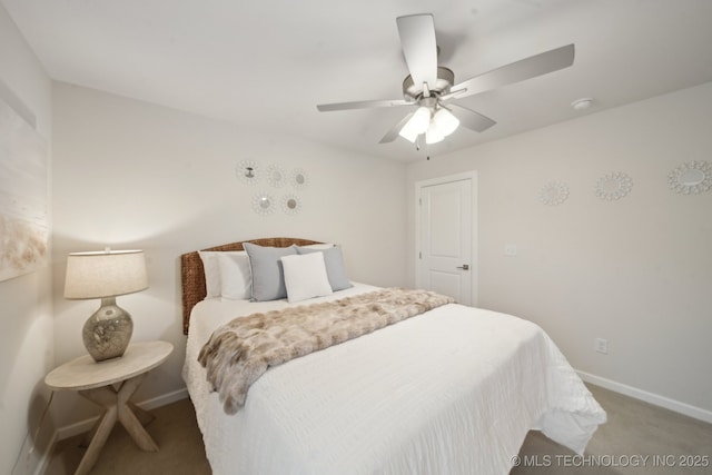 carpeted bedroom with ceiling fan and baseboards