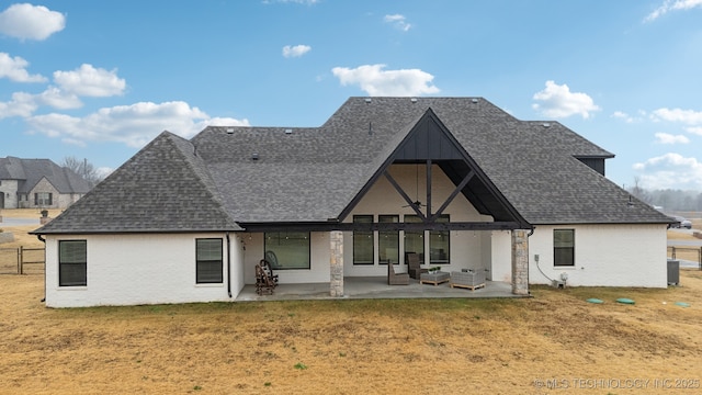 back of house with a shingled roof, fence, a lawn, and a patio